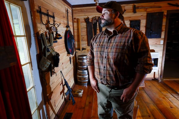Trent Tye, who lives near Calhoun State Prison, says that drug trafficking near the facility is so common that he keeps an AR 15 and tactical gear near his back door. (Miguel Martinez/ AJC)