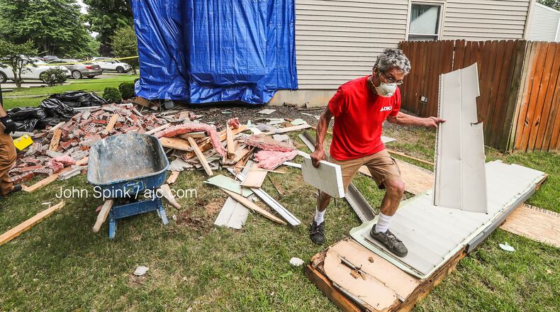 Jose Avalon of Big Bear Restoration removes debris Monday morning from the scene of a fatal crash into a home at the corner of Bell Drive and Afton Way in Smyrna.