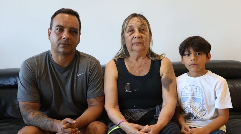 Grian Serrano, left, his mother, Ingrid Rochabrun, and his son, Gael, sit at the home where they are staying with relatives in Caracas, Venezuela, after surviving the back-to-back earthquakes that destroyed their apartment building in Caraballeda, Monday, June 29, 2026. Serrano also survived the 1999 mudslides that struck La Guaira. (AP Photo/Pedro Mattey)