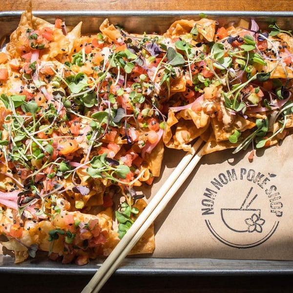 The Ahi Tuna Nachos at Nom Nom Poke Shop include marinated ahi tuna, pico de gallo, pickled onion, micro herbs and creamy togarashi. (Courtesy of Nom Nom Poke Shop)