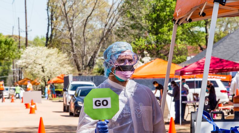 David Bentley, an engineer for Coca Cola, volunteers as crowd control with Ethne Health in Clarkston on Friday, April 3, 2020. The community health provider, inpartnership with the City of Clarkston, community churches and food banks provides free corona virus testing for people showing symptoms who live in the Clarkston area. The testing will continue on Saturday. (Jenni Girtman for the Atlanta Journal-Constitution)