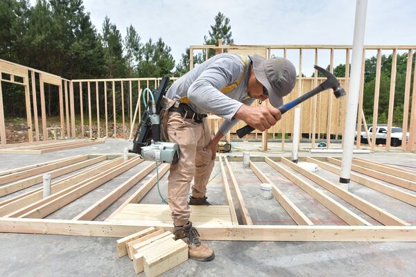Gonzalo Gonzalez prepares framing of a new construction townhome community in Jonesboro. Home Depot has introduced Blueprint Takeoffs, which it says can cut the time pro contractors need to price a build. (Hyosub Shin/AJC)