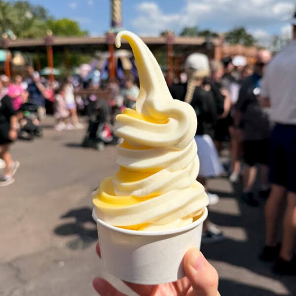 A hand holds up the DOLE Whip soft-serve cup at Aloha Isle Refreshments in Adventureland on May 14, 2026. (Photo/Grace Donovan)
