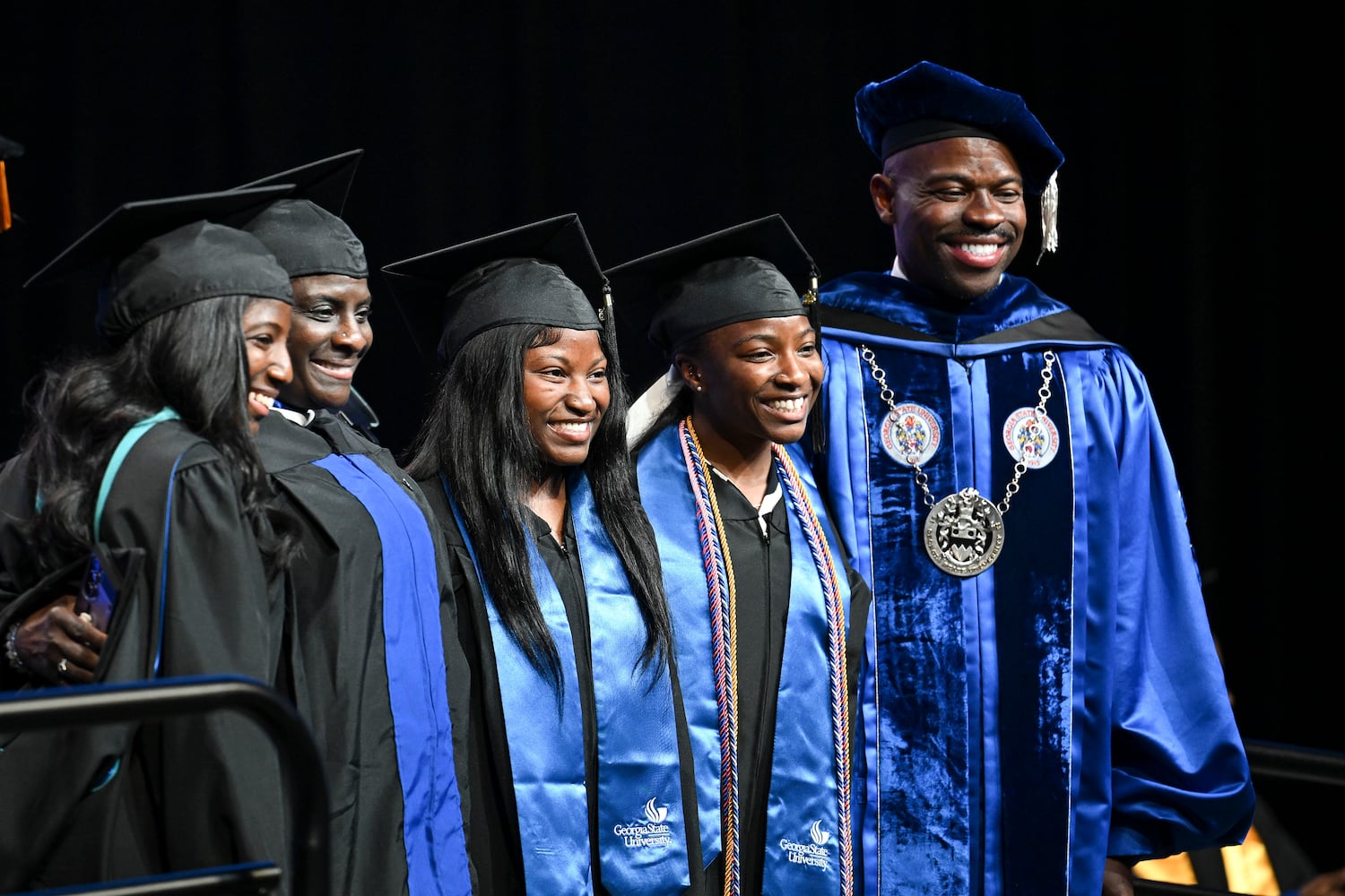 Georgia State graduates (from left) Rakiya Lee, her mother Quila Lee and twin sisters Kalaya, and Kamiya Lee pose for a photo along with Georgia State President M. Brian Blake during Georgia State University’s Spring commencement ceremony for the College of Arts & Sciences Wednesday, May 7, 2025 in Atlanta. (Daniel Varnado/For the Atlanta Journal-Constitution)