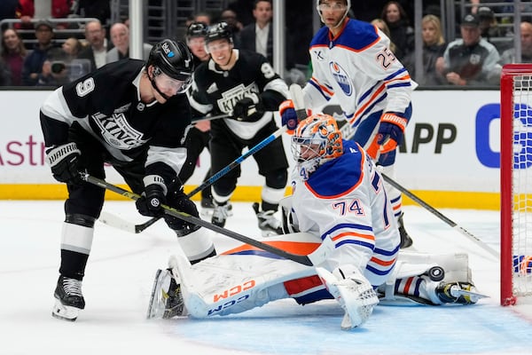 Los Angeles Kings right wing Adrian Kempe, left, scores on Edmonton Oilers goaltender Stuart Skinner during the second period in Game 1 of an NHL hockey first-round playoff series Monday, April 21, 2025, in Los Angeles. (AP Photo/Mark J. Terrill)