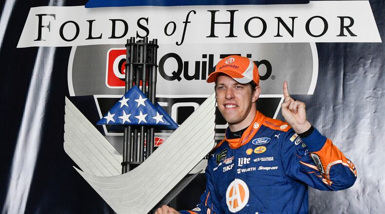 Brad Keselowski poses with the trophy in victory lane after winning a NASCAR Monster Cup series auto race at Atlanta Motor Speedway Sunday.