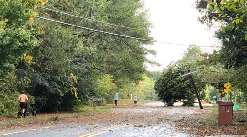 A tilting tree and downed power line on Sewell Mill Road near Johnson Ferry Road in east Cobb. (Photo by Rich Danielson / for the AJC )
