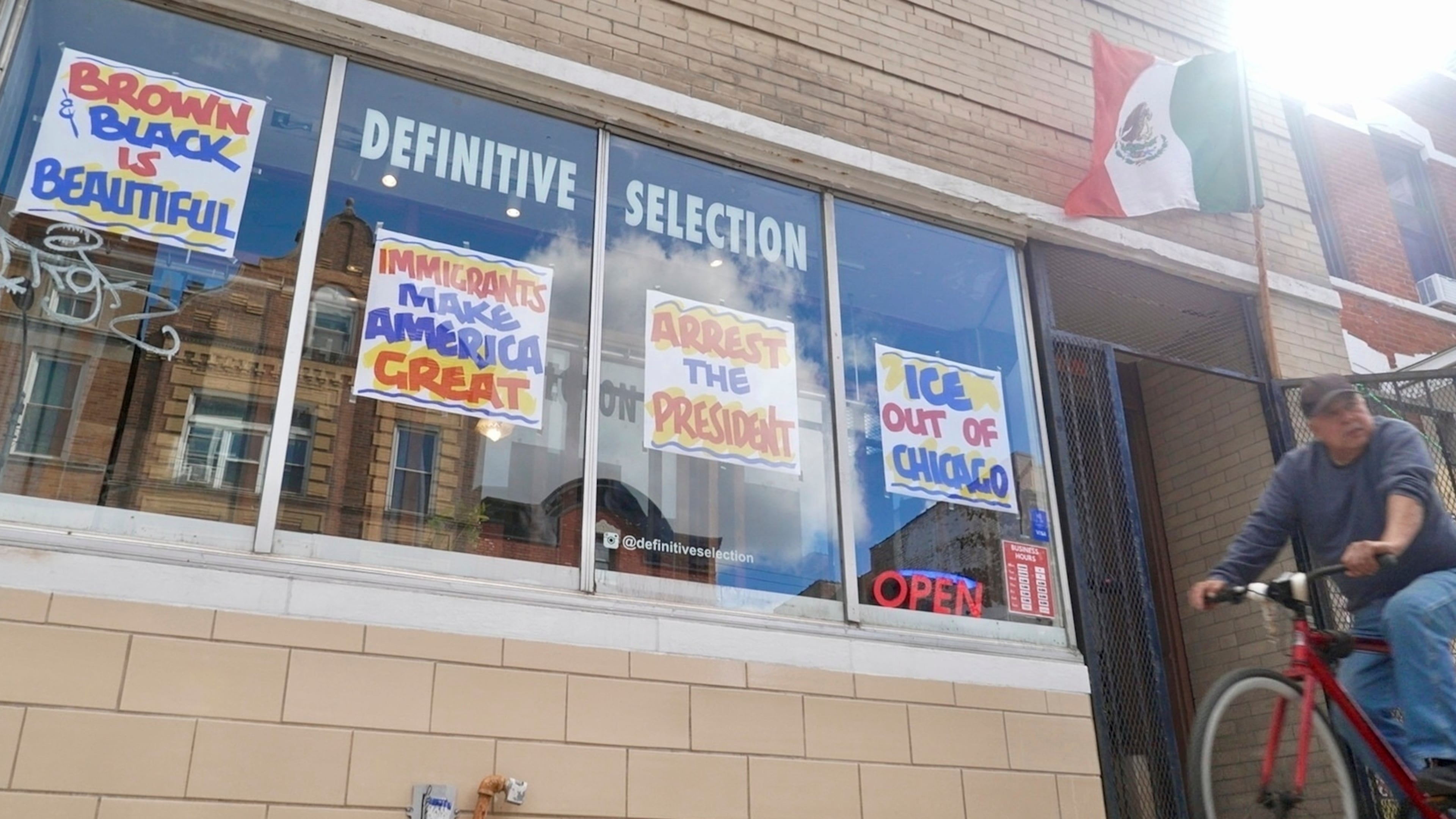 FILE - A bicyclist passes Definitive Selection clothing store, one of many businesses in the predominantly Latino neighborhood that has seen a slowdown in foot traffic since President Donald Trump's threats of a federal law enforcement intervention, Sept. 5, 2025, in Chicago. (AP Photo/Mark Vancleave, File)