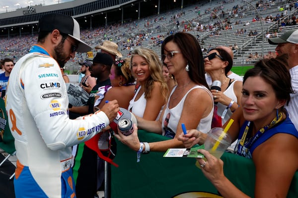 Driver Chase Elliott signs autographs for fans before a NASCAR Cup Series auto race, Saturday, June 28, 2025, in Hampton, Ga. (AP Photo/Butch Dill)