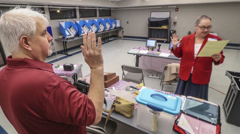 Poll worker Jerry Shaw (left) is sworn in by Julie Moore before voters trickled in slowly at Best Friend Park precinct at 6224 Jimmy Carter Blvd in Norcross to vote on Gwinnett’s MARTA referendum early Tuesday, March 19, 2019. JOHN SPINK/JSPINK@AJC.COM