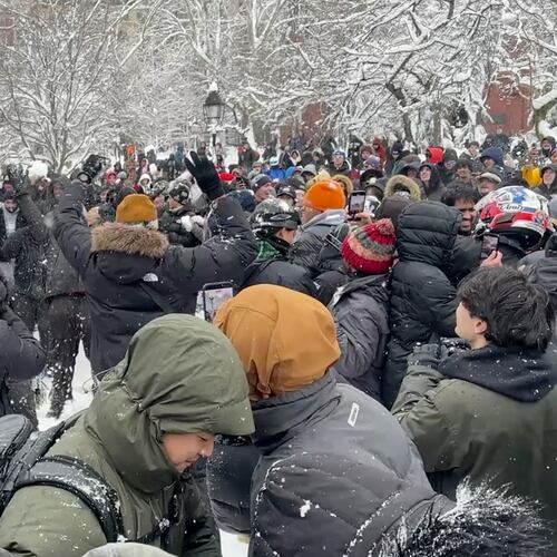 In this photo taken from video, people throw and duck snowballs during a snowball fight at Washington Square Park, Monday, February. 23, 2026 in New York. (AP Photo/David R. Martin)