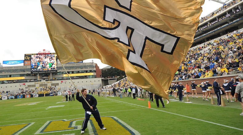 A Georgia Tech cheerleader waves the giant GT flag after a Georgia Tech touchdown in Bobby Dodd Stadium on Saturday, October 19, 2013. JOHNNY CRAWFORD / AJC file