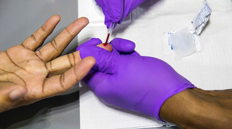 Bible Way Ministries International Pastor Monte Norwood gets his blood drawn while being tested for HIV/AIDs in the Aids Healthcare Foundation mobile testing bus on Dec. 11, 2019. (ALYSSA POINTER/ALYSSA.POINTER@AJC.COM)