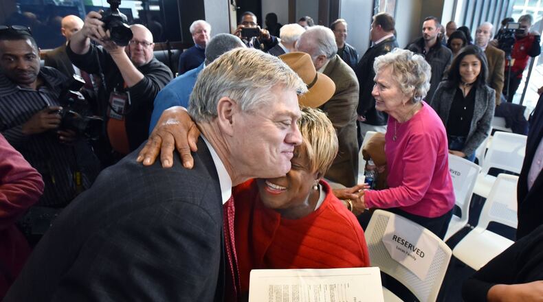Rubye Lucas, wife of the late Bill Lucas, hugs former Braves star Dale Murphy on Thursday as he holds a copy of his 1978 contract, signed by Lucas. HYOSUB SHIN / HSHIN@AJC.COM
