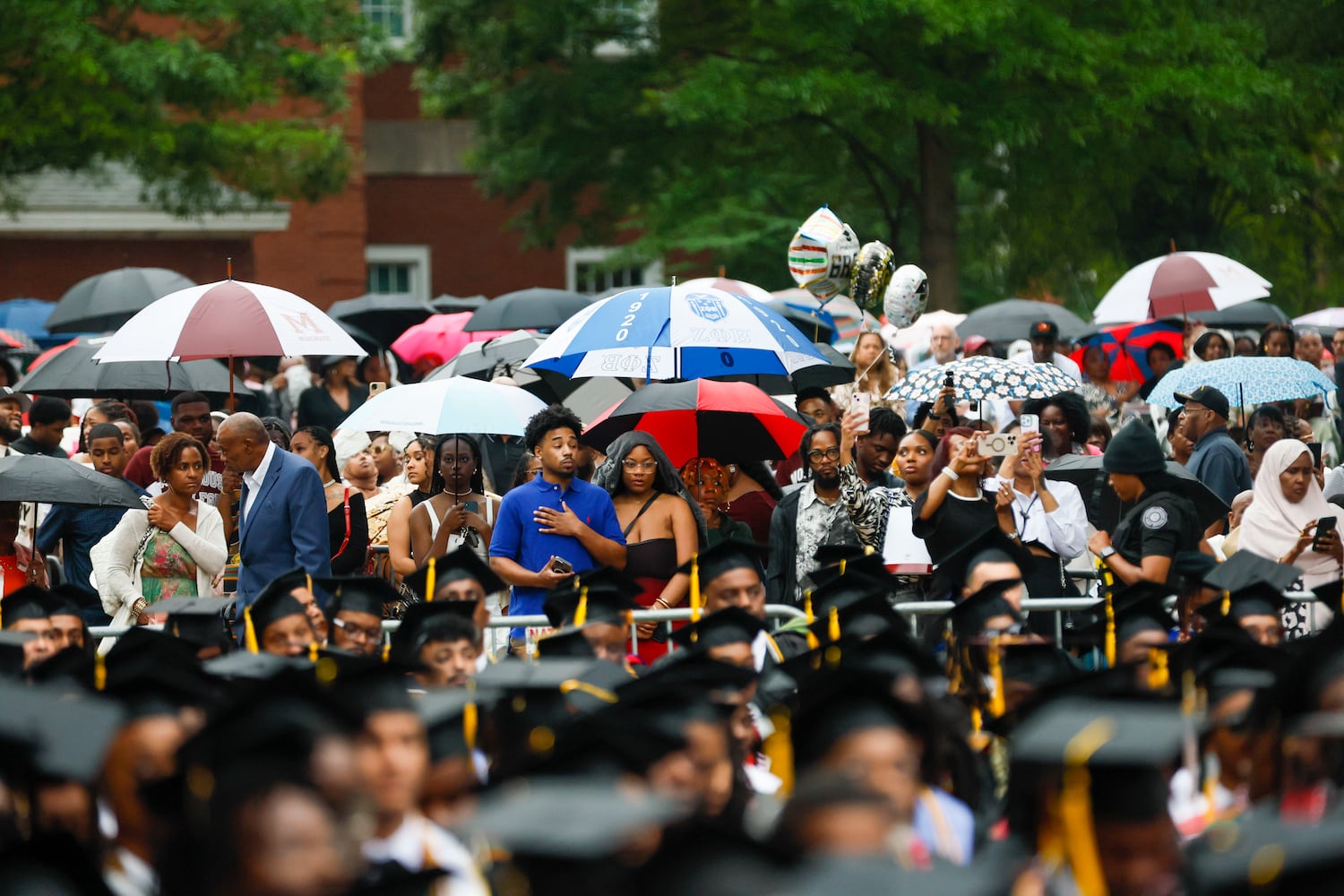 Family members cover themselves with umbrellas as rain starts to fall during Morehouse College's 141st Commencement Ceremony on Sunday, May 18, 2025.
(Miguel Martinez/ AJC)