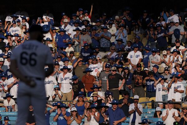 FILE - Fans cheer as Los Angeles Dodgers pitcher Tanner Scott prepares to throw during the ninth inning of a baseball game against the San Francisco Giants in Los Angeles, Saturday, June 14, 2025. (AP Photo/Jessie Alcheh, File)
