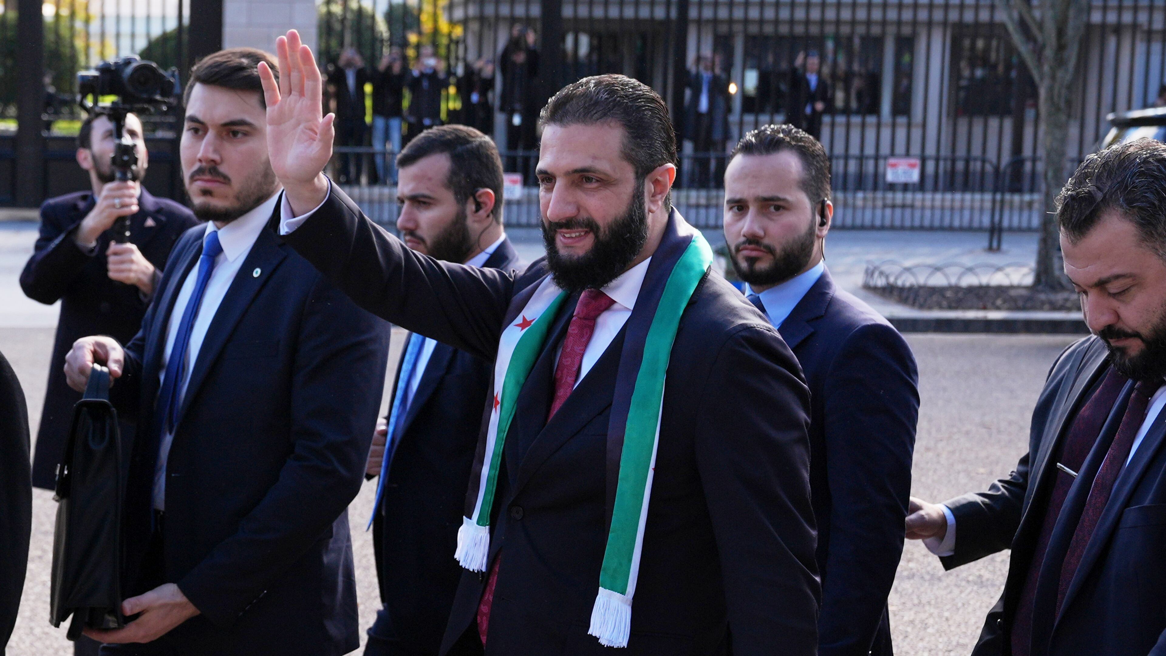 Syria's President Ahmed al-Sharaa waves as he greets supporters outside of the White House, Monday, Nov. 10, 2025, in Washington, following a meeting with President Donald Trump. (AP Photo/Jacquelyn Martin)