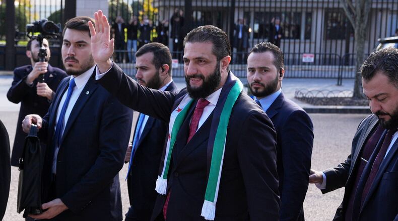 Syria's President Ahmed al-Sharaa waves as he greets supporters outside of the White House, Monday, Nov. 10, 2025, in Washington, following a meeting with President Donald Trump. (AP Photo/Jacquelyn Martin)