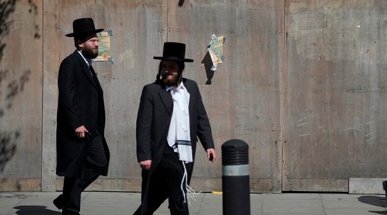 Two men walk in London, Thursday, April 30, 2026, near the scene where two people were recently stabbed in the Golders Green neighbourhood, that has a large Jewish community. (AP Photo/Alastair Grant)
