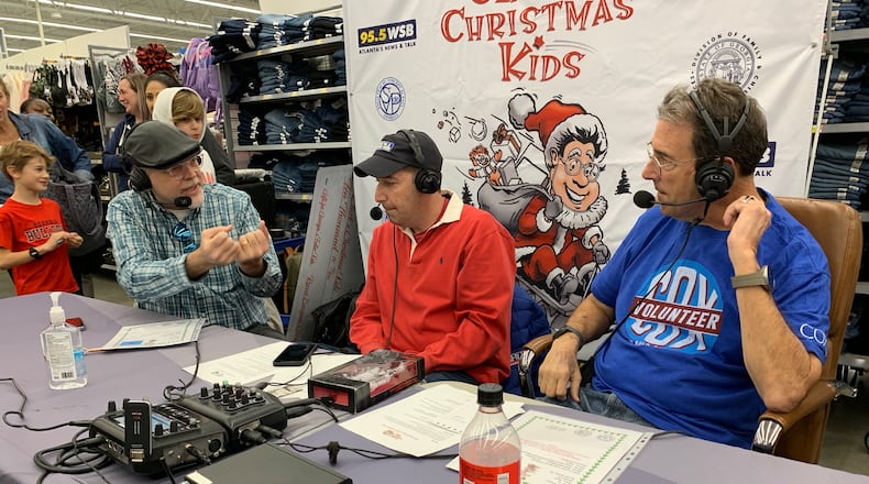 At a Norcross Walmart earlier this month, WSB's Eric Von Haessler and Mark Arum join Clark Howard to help raise money for Clark's Christmas Kids. (PHOTO: Rodney Ho / rho@ajc.com)