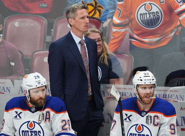 Edmonton Oilers head coach Kris Knoblauch looks on from the bench with Leon Draisaitl (29) and Connor McDavid (97) during the third period in Game 3 of the NHL hockey Stanley Cup finals against the Florida Panthers in Sunrise, Fla., Monday, June 9, 2025. (Nathan Denette/The Canadian Press via AP)