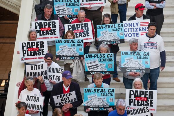 Citizens with the Georgians for Truth hold signs during the first day of the legislative session at the state Capitol on Monday, Jan. 13, 2025, in Atlanta. The conservative election group is advocating for paper ballots, saying Georgia’s voting machines are untrustworthy. (Jason Getz/AJC 2025)