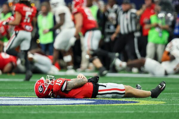 Georgia quarterback Carson Beck (15) lays on the ground after getting injured on the last play of the first half of Saturday's SEC Championship Game.