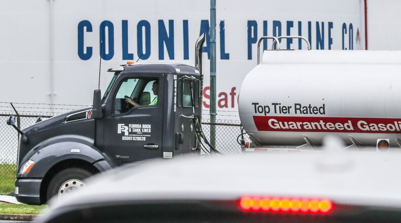 Gasoline tankers pass by the Colonial Pipeline storage tanks in Austell on Monday. A ransomware attack has shut down the Alpharetta-based, Colonial Pipeline that delivers roughly 45% of fuel consumed on the East Coast. (John Spink / John.Spink@ajc.com)