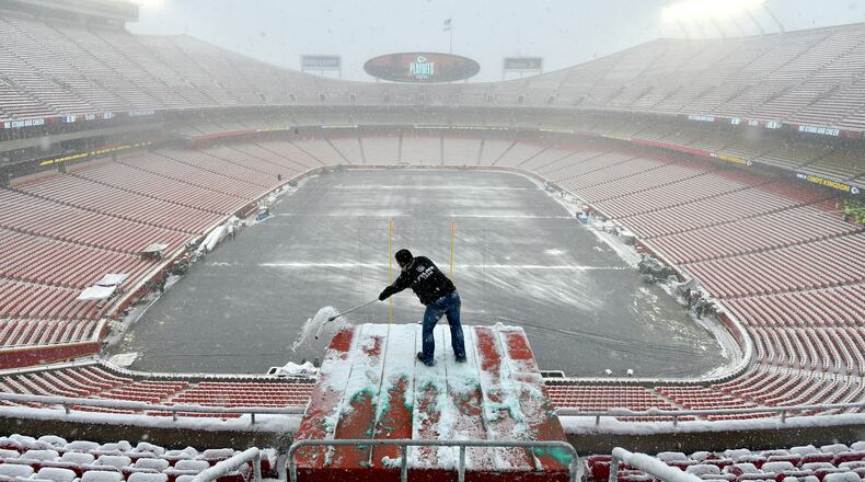 Kyle Haraugh, of NFL Films, clears snow from a camera location at Arrowhead Stadium before an NFL divisional football playoff game between the Kansas City Chiefs and the Indianapolis Colts, in Kansas City, Mo., Saturday, Jan. 12, 2019. (AP Photo/Ed Zurga)