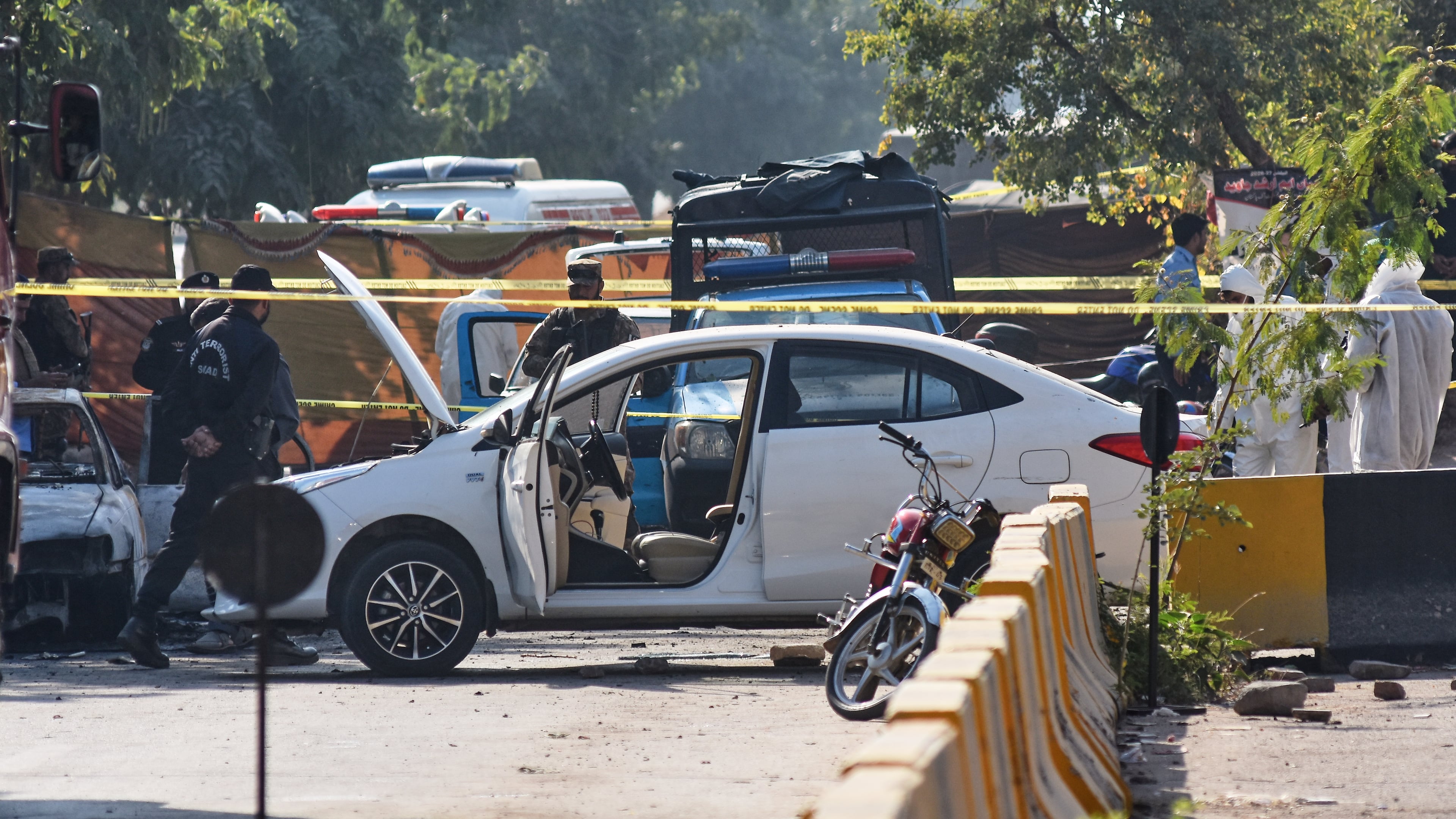 Pakistan's investigators examine the site following a suicide bombing outside the gates of a district court, in Islamabad, Pakistan, Tuesday, Nov. 11, 2025. (AP Photo/W.K. Yousufzai)