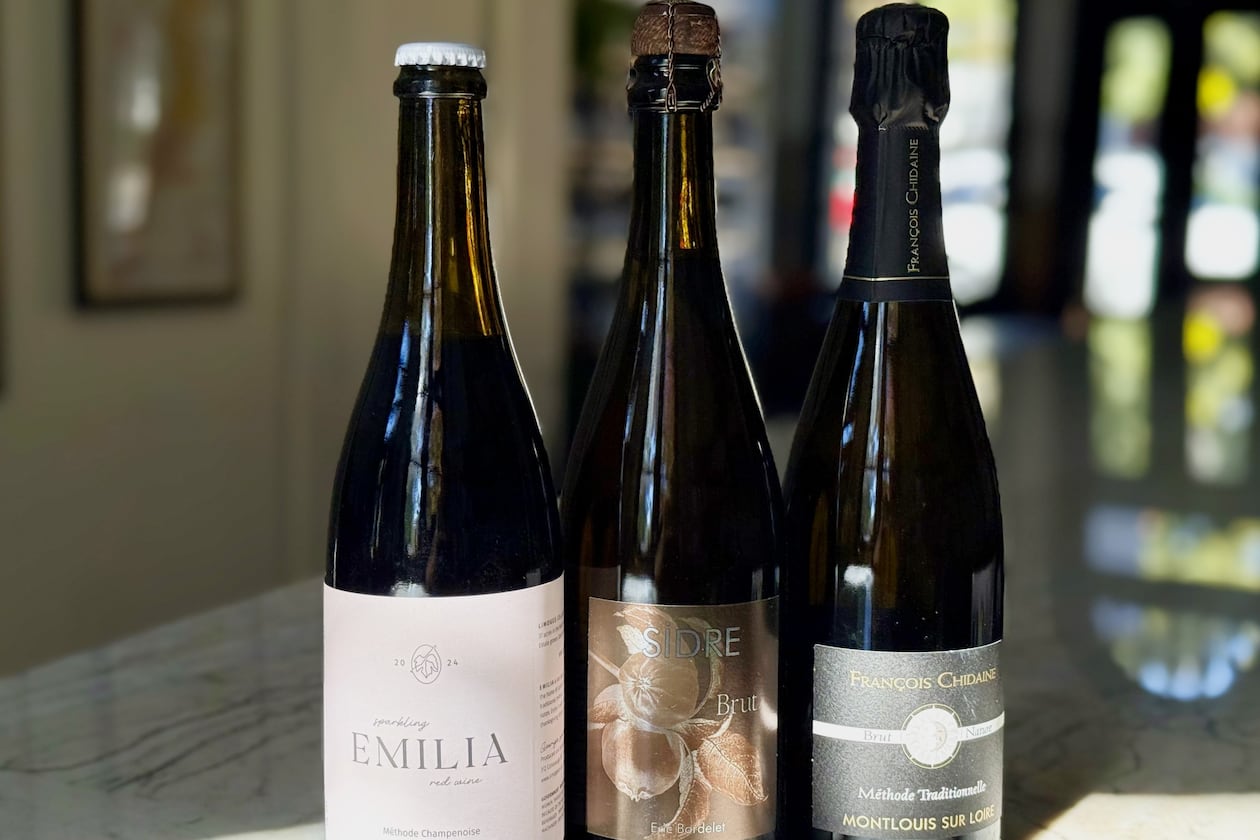Sparkling wine recommendations for Thanksgiving. Limoges Cellars ‘Emilia’ Sparkling Red (left), Eric Bordelet Cider (center) and Domaine François Chidaine Montlouis-Sur-Loire Brut Nature (right). (Krista Slater for the AJC)