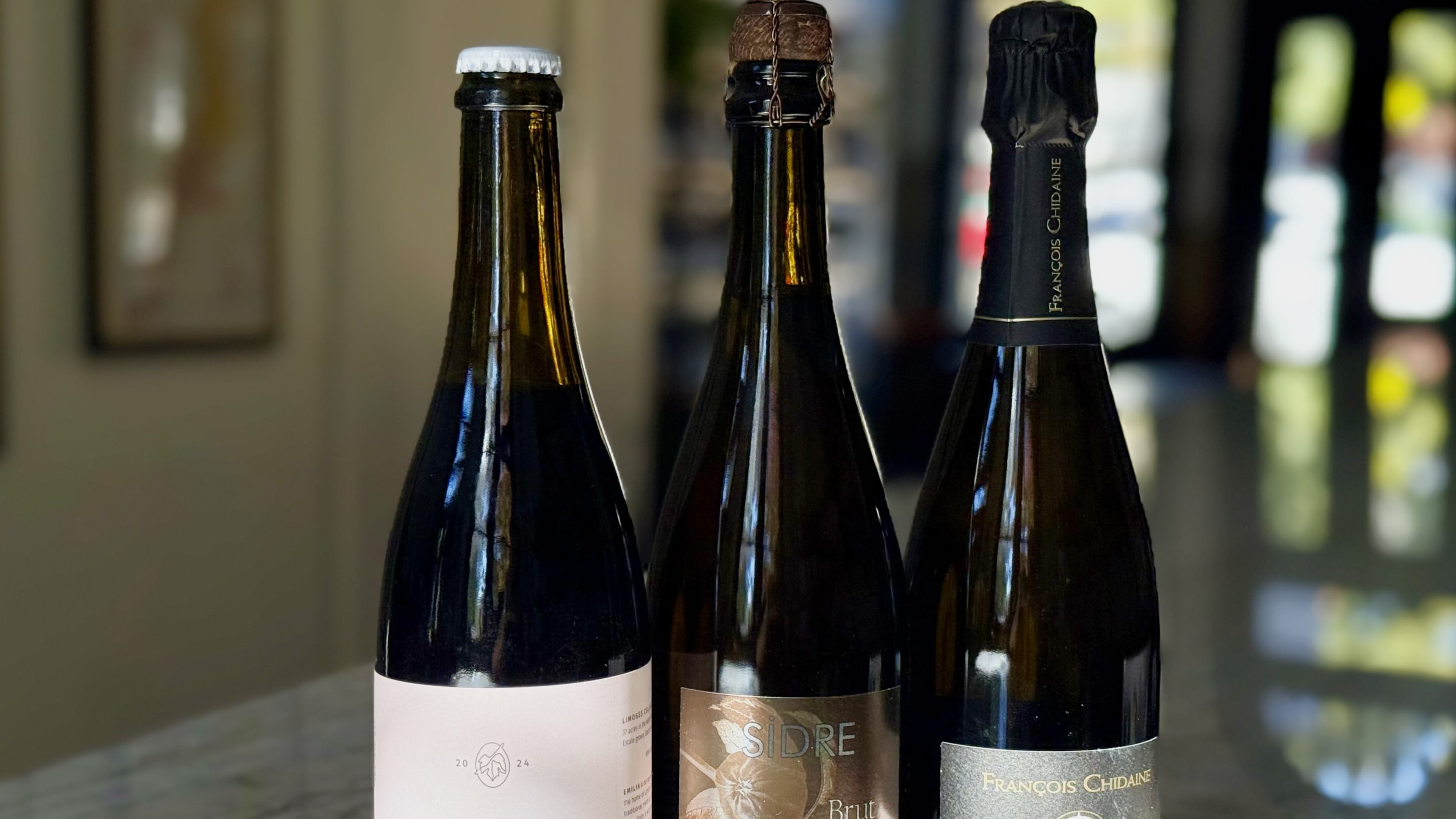 Sparkling wine recommendations for Thanksgiving. Limoges Cellars ‘Emilia’ Sparkling Red (left), Eric Bordelet Cider (center) and Domaine François Chidaine Montlouis-Sur-Loire Brut Nature (right). (Krista Slater for the AJC)