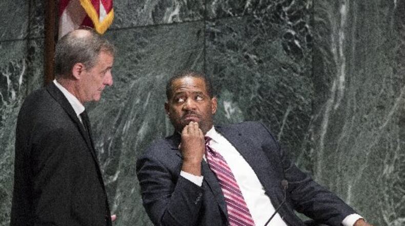Atlanta Councilman Howard Shook (left) and council president Ceasar Mitchell confer during the Dec. 4 city council meeting, at which 288 employees were approved to buy back in to the city’s defined benefit pension system.