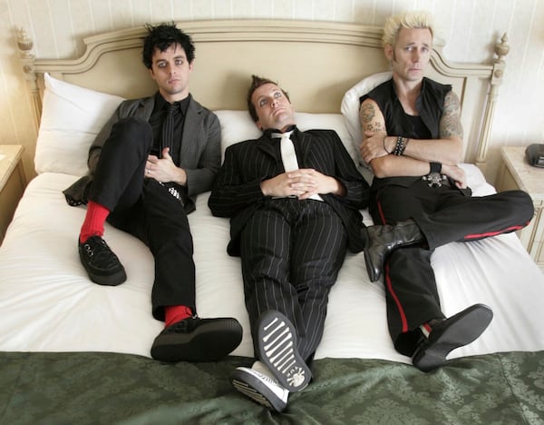 FILE - Members of Green Day, from left, Billie Joe Armstrong,, Tre Cool and Mike Dirnt pose in their hotel room in Toronto on Sept. 23, 2004. (Adrian Wyld/The Canadian Press via AP, File)