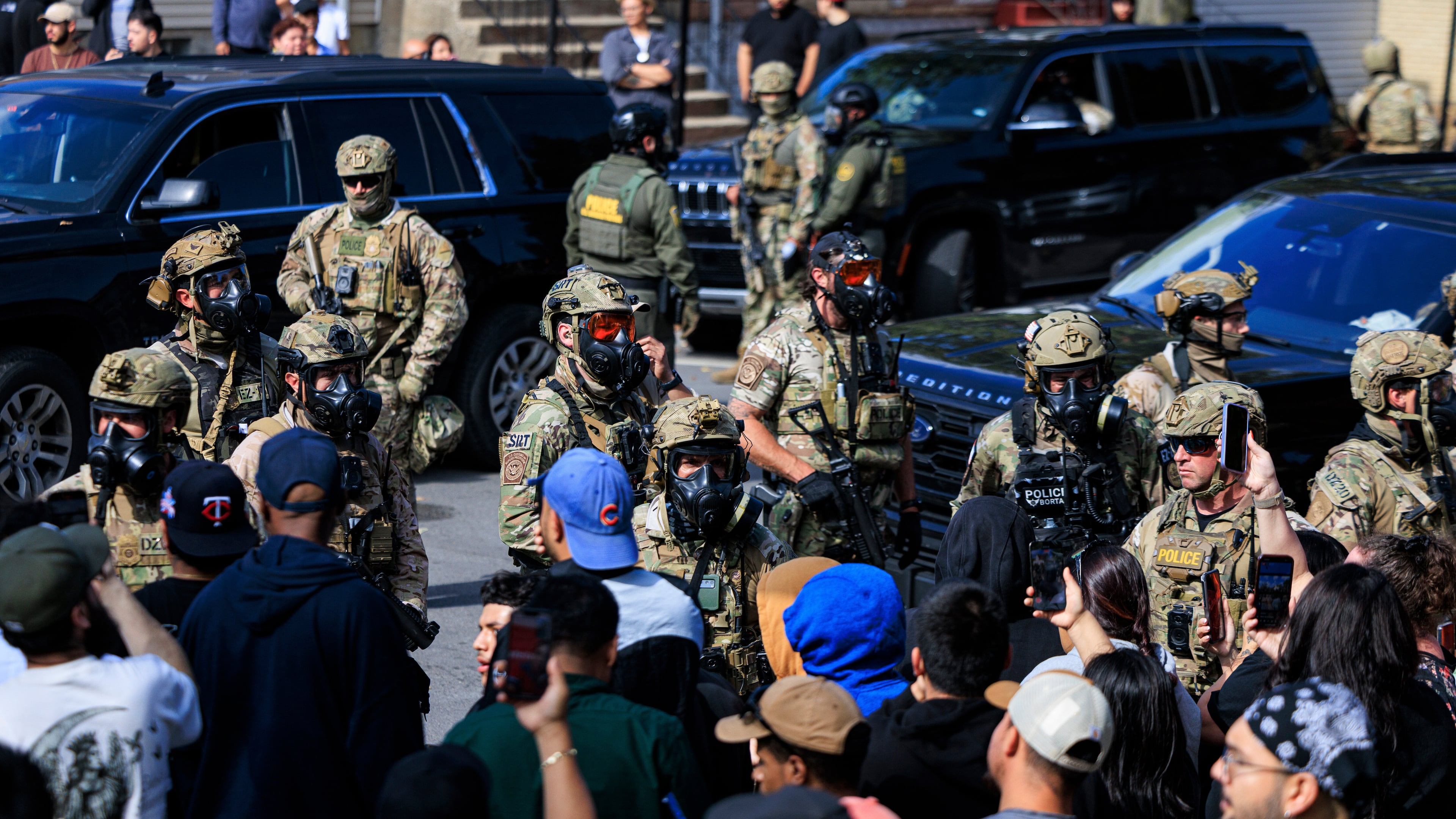 Government officials watch protesters gathering in Chicago, Tuesday, Oct. 14, 2025. (Anthony Vazquez/Chicago Sun-Times via AP)