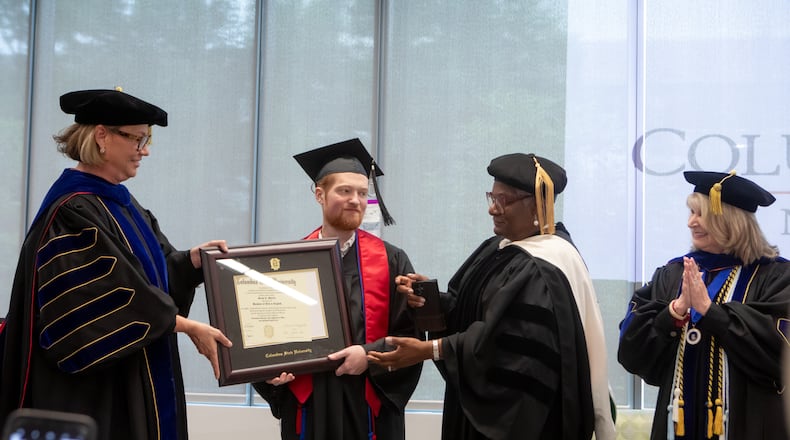Columbus State University President Stuart Rayfield (left) presents Grant Martin his diploma. Annice Yarber-Allen, dean of the College of Letters and Science, and Margie Yates, dean of the College of Education and Health Professions (right), were also in attendance Saturday.