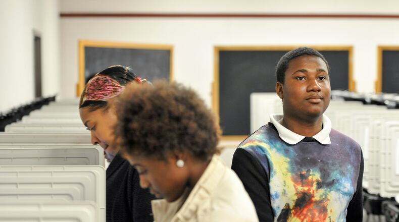 Demarcus Scrubb, 18, right, leaves after casting his ballot Oct. 31. He voted with a group of Columbia High School seniors as a part of their coursework and to build familiarity with the electoral process. (DAVID BARNES / DAVID.BARNES@AJC.COM)