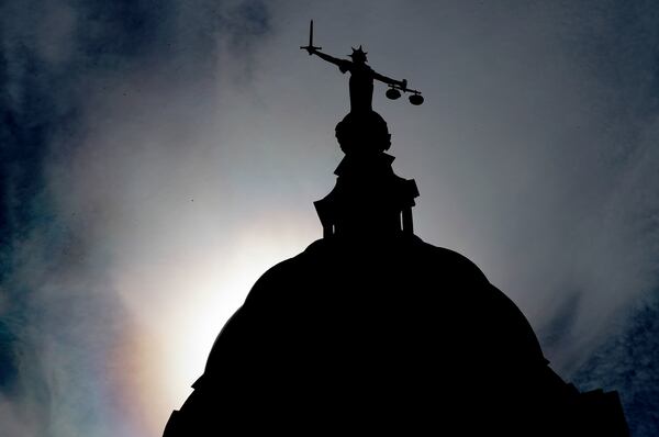 FILE - A statue of liberty is silhouetted as it stands atop the Old Bailey, Central Criminal Court, in London, Thursday, Aug. 8, 2019. (AP Photo/Frank Augstein, File)
