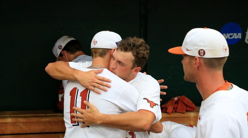 Texas right fielder Duke Ellis (11) and pitcher Bryce Elder hug in the dugout following the team's 6-1 loss to Florida in an NCAA College World Series baseball elimination game in Omaha, Neb., Tuesday, June 19, 2018. (AP Photo/Nati Harnik)