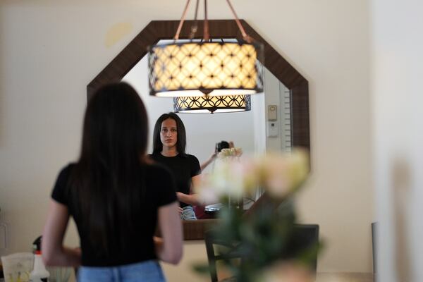 Oksana Tarasiuk looks in the mirror of the apartment she shared with her husband, Maksym Chernyak, who died in ICE custody after being held at Krome Detention Center, Tuesday, April 22, 2025, in Hallandale Beach, Fla. (AP Photo/Rebecca Blackwell)