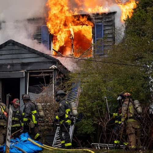 Atlanta firefighters battle a blaze at a home on Fair Street in southwest Atlanta late last year. The former head of the city's firefighter union is suing the city, the mayor and fire chief, alleging retaliation against him for advocating for better working conditions. (Ben Hendren for the AJC)