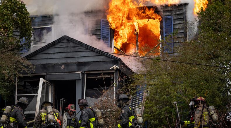 Atlanta firefighters battle a blaze at a home on Fair Street in southwest Atlanta late last year. The former head of the city's firefighter union is suing the city, the mayor and fire chief, alleging retaliation against him for advocating for better working conditions. (Ben Hendren for the AJC)