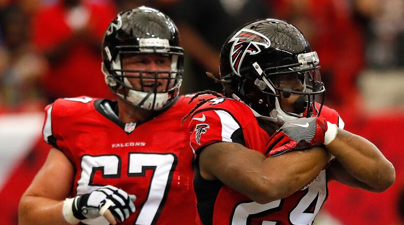 Devonta Freeman of the Atlanta Falcons reacts with Andy Levitre after scoring a touchdown against the Carolina Panthers at Georgia Dome on October 2, 2016 in Atlanta, Georgia.