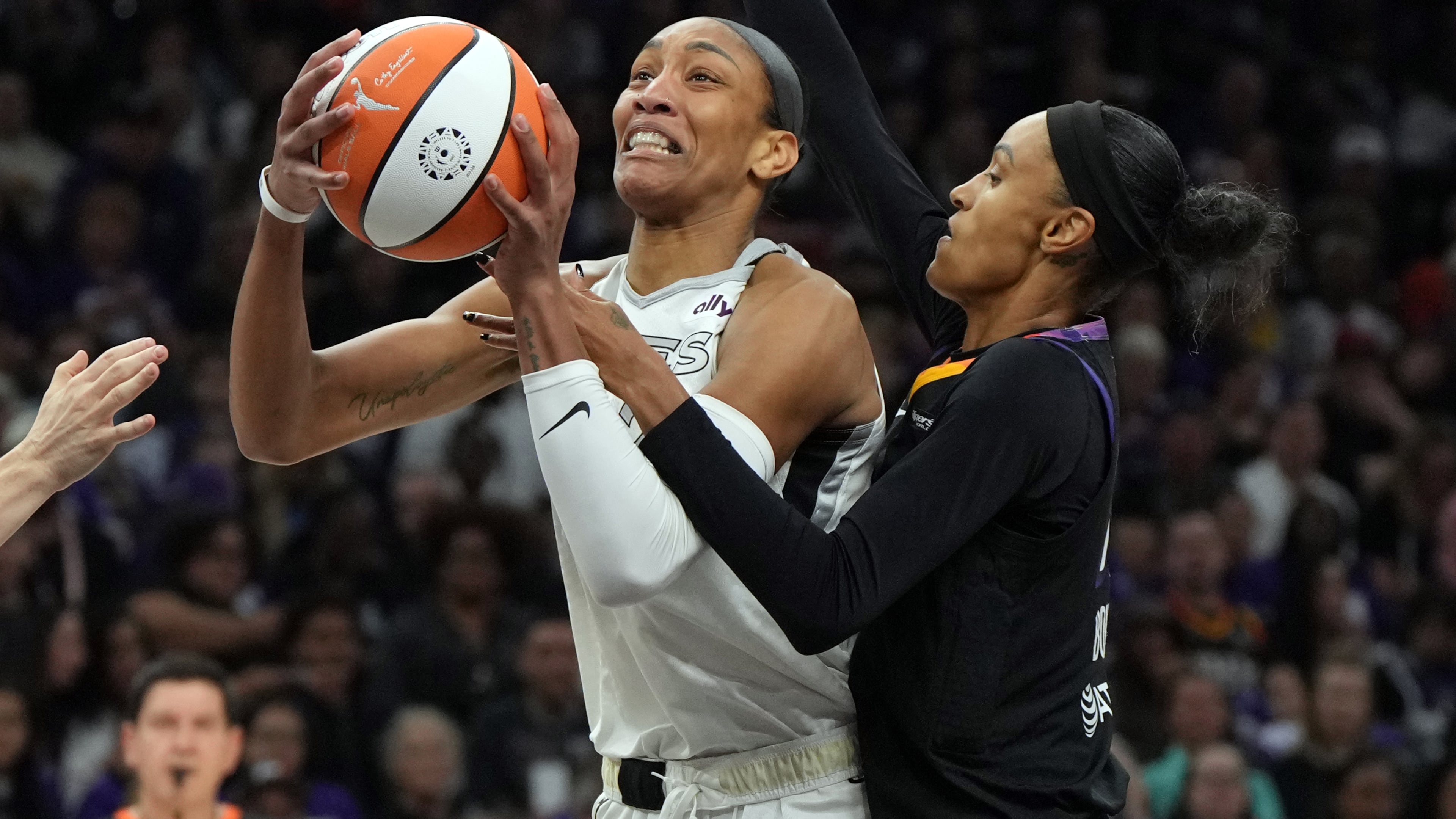 Phoenix Mercury forward DeWanna Bonner, right, fouls Las Vegas Aces center A'ja Wilson, left, during the first half of Game 4 of the WNBA basketball finals, Friday, Oct. 10, 2025, in Phoenix. (AP Photo/Rick Scuteri)