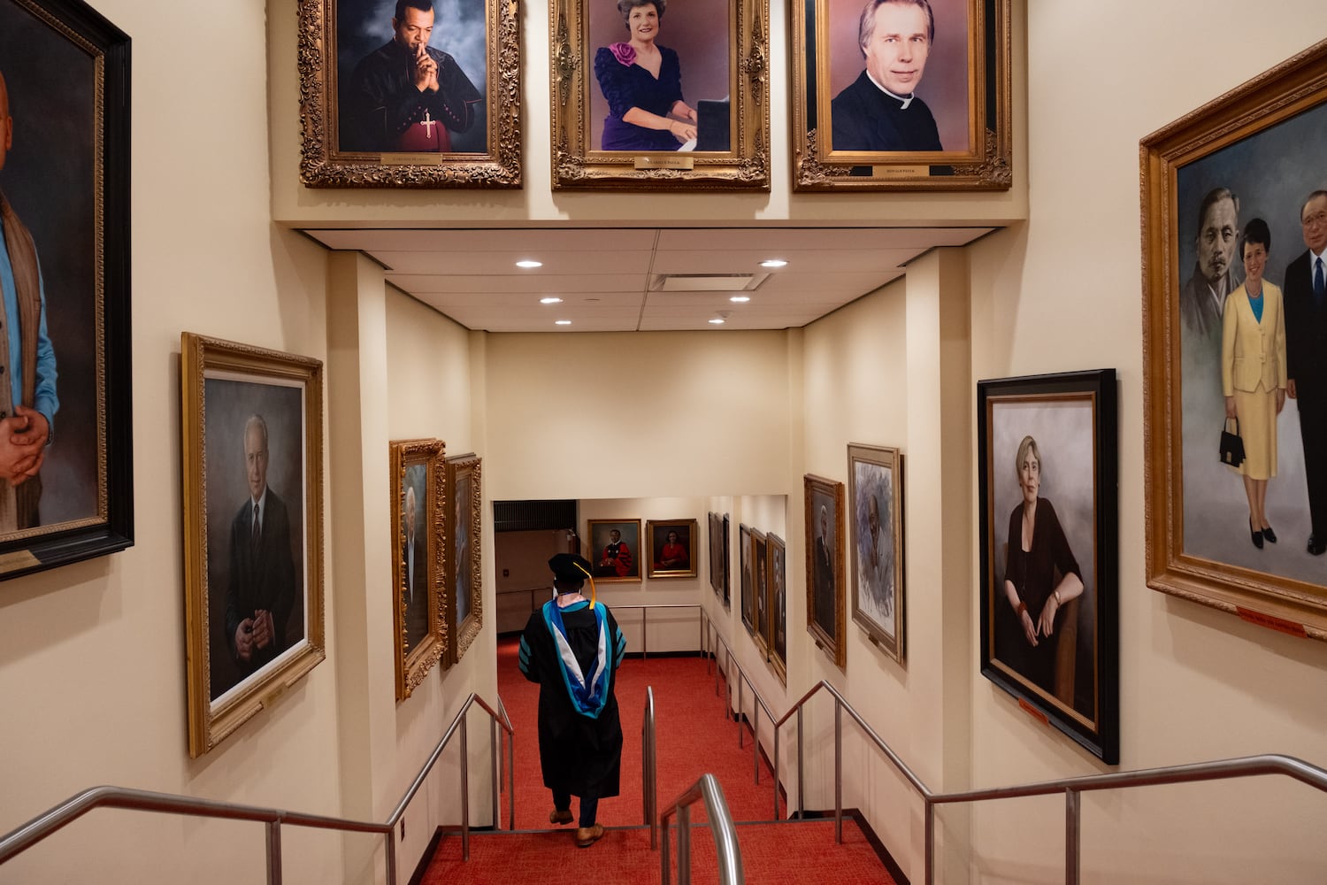 A student walks past paintings in Morehouse College’s International Hall of Honor while heading to his seat for the Morehouse School of Medicine graduation ceremony on Saturday, May 16, 2026, in Atlanta. (Ben Gray for the AJC)