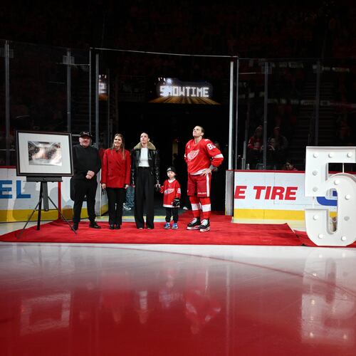 Detroit Red Wings right wing Patrick Kane (88) stands with his family, from left to right, father Patrick Sr., mother Donna, girlfriend Amanda Grahovec, and son Patrick III while being honored by the team for scoring his 500th career goal earlier in the month before an NHL hockey game against the Ottawa Senators, Sunday, Jan. 18, 2026, in Detroit. (AP Photo/Lon Horwedel)