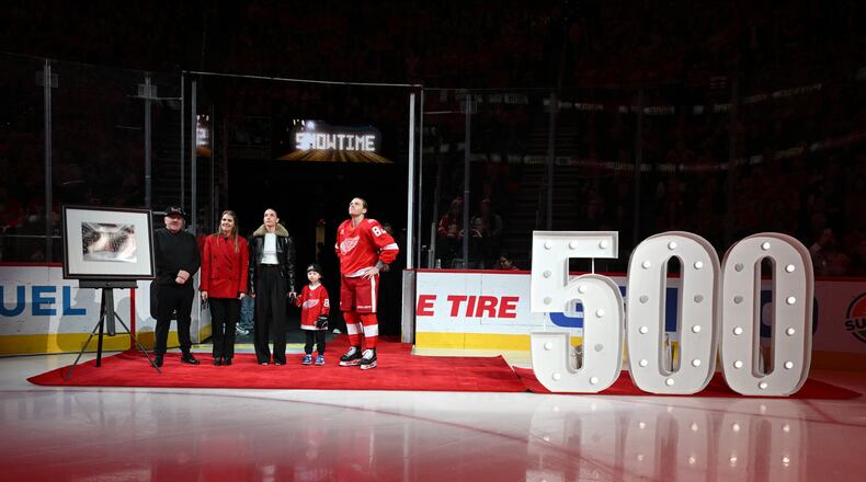 Detroit Red Wings right wing Patrick Kane (88) stands with his family, from left to right, father Patrick Sr., mother Donna, girlfriend Amanda Grahovec, and son Patrick III while being honored by the team for scoring his 500th career goal earlier in the month before an NHL hockey game against the Ottawa Senators, Sunday, Jan. 18, 2026, in Detroit. (AP Photo/Lon Horwedel)