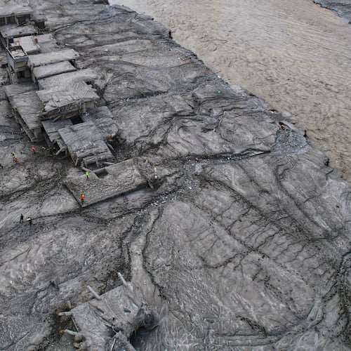 A drone view shows rescue workers inspect the area and damaged structures following recent flash flooding along the Trishuli River in the Devighat area of Nuwakot district, Nepal, Saturday, Aug. 29, 2026. (AP Photo/Rajesh Kumar Singh)
