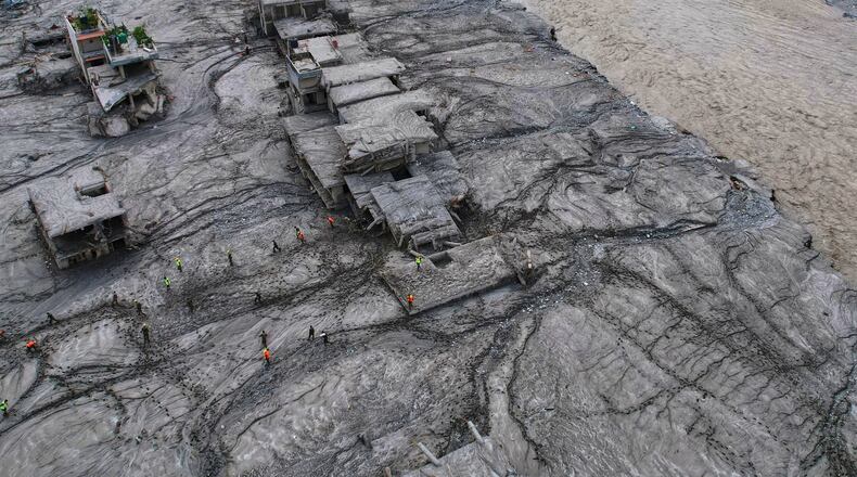 A drone view shows rescue workers inspect the area and damaged structures following recent flash flooding along the Trishuli River in the Devighat area of Nuwakot district, Nepal, Saturday, Aug. 29, 2026. (AP Photo/Rajesh Kumar Singh)