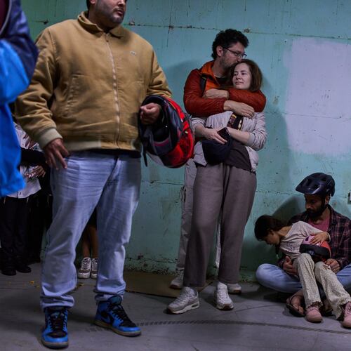 People take shelter as air raid sirens warning of incoming Iranian missiles in Tel Aviv, Israel, Saturday, March 7, 2026. (AP Photo/Oded Balilty)